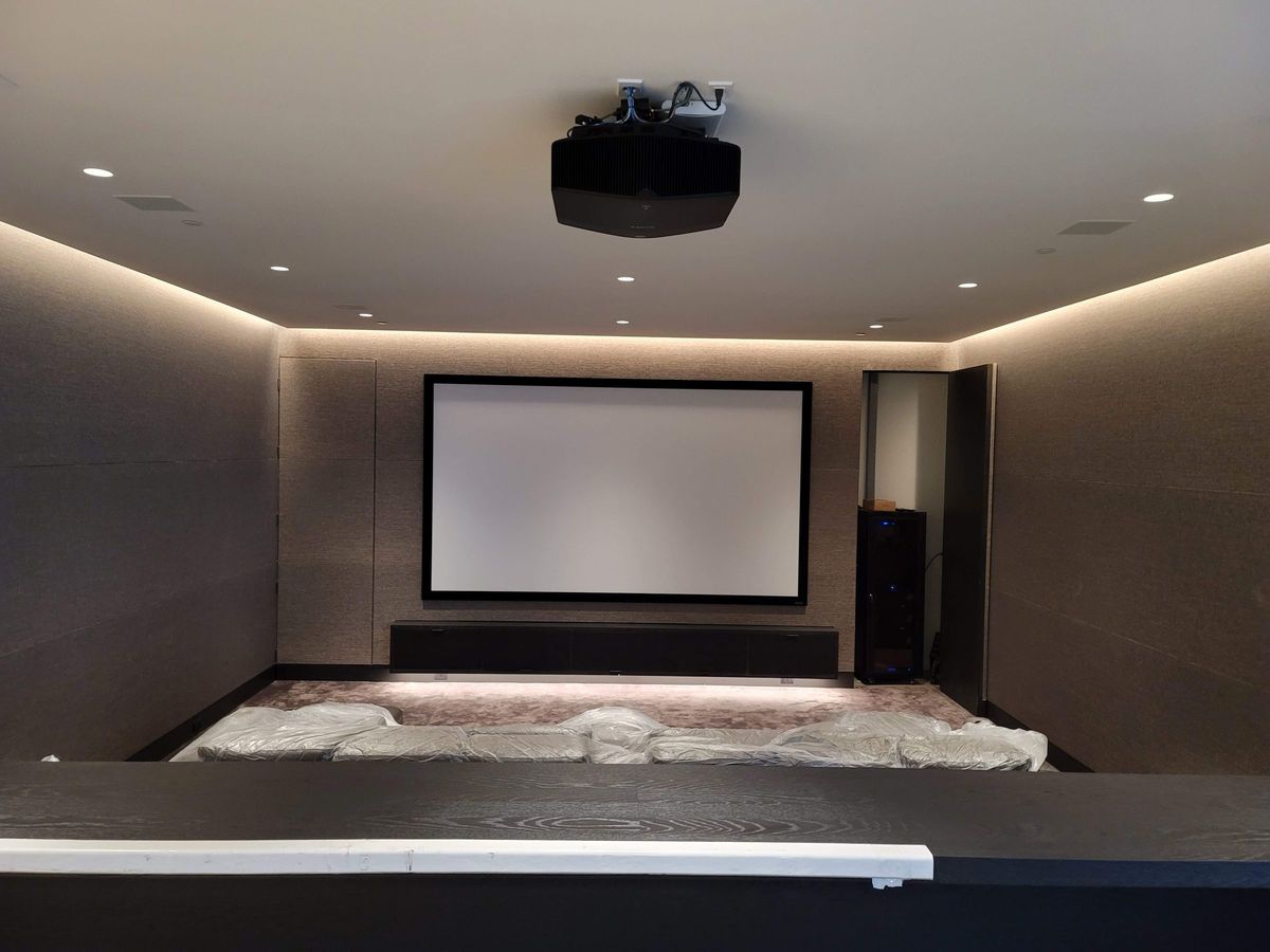Dedicated theater with projection screen, ceiling-mounted projector and recessed lighting