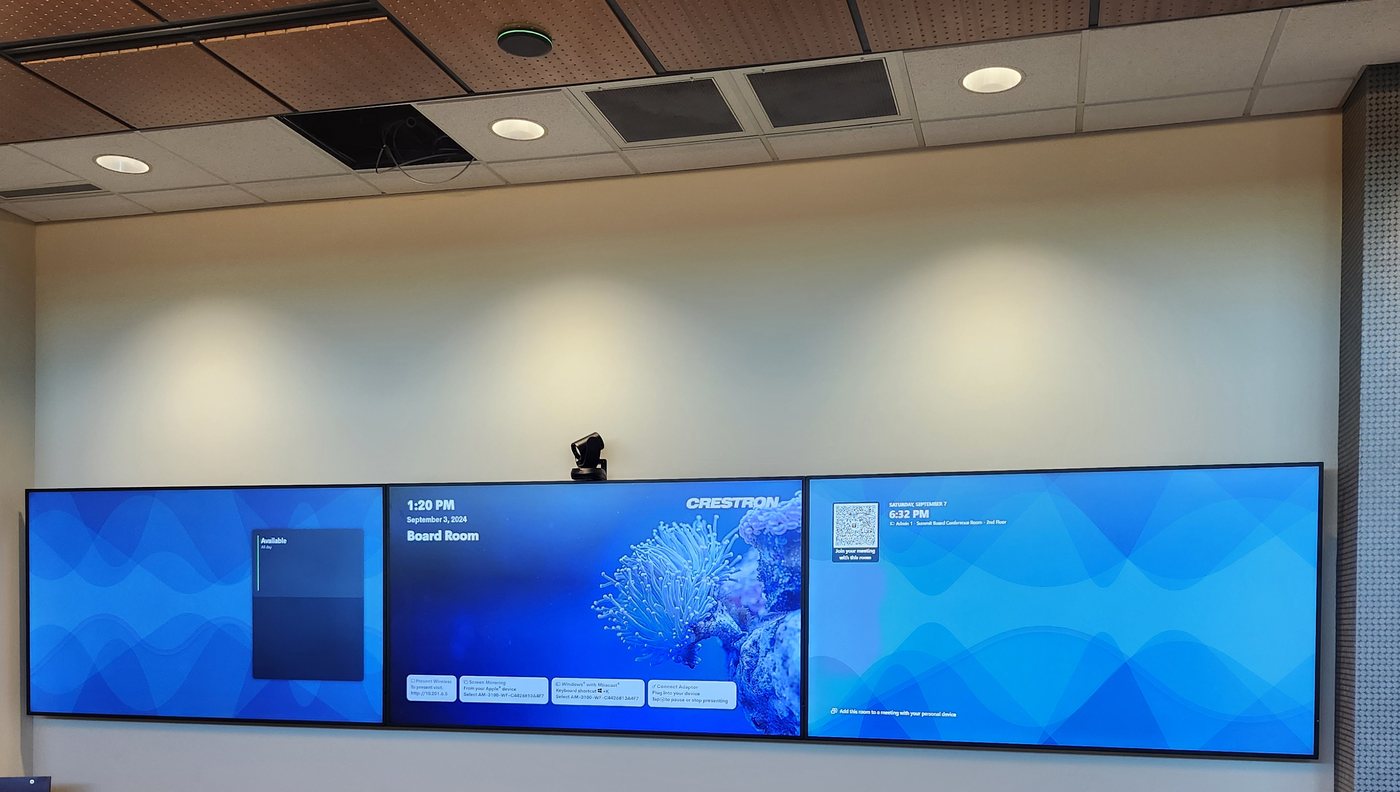 Three-display board room wall with a Crestron room screen and conference camera, installed by Obsidian AV in downtown Houston