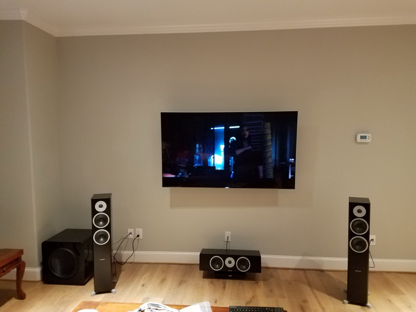 River Oaks living room with wall-mounted TV, floor-standing tower speakers, center channel and subwoofer