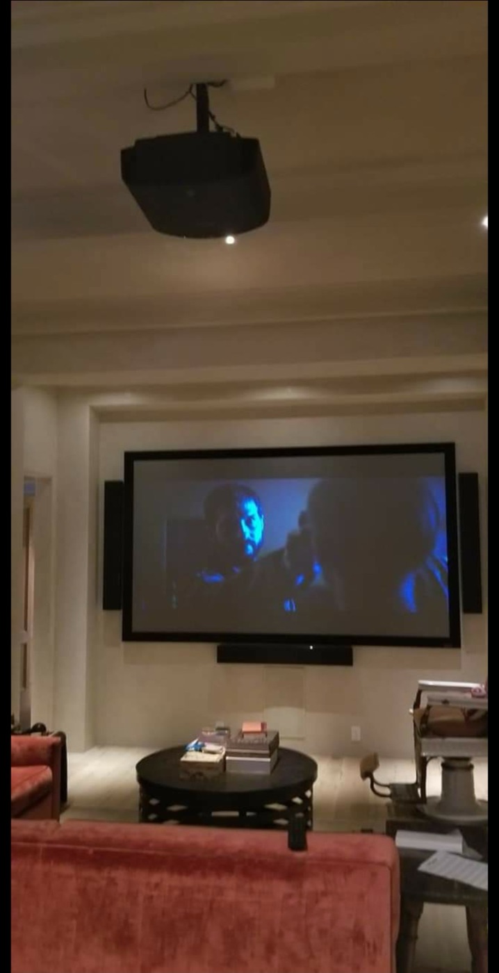 River Oaks media room with ceiling-mounted projector, framed screen and on-wall speakers