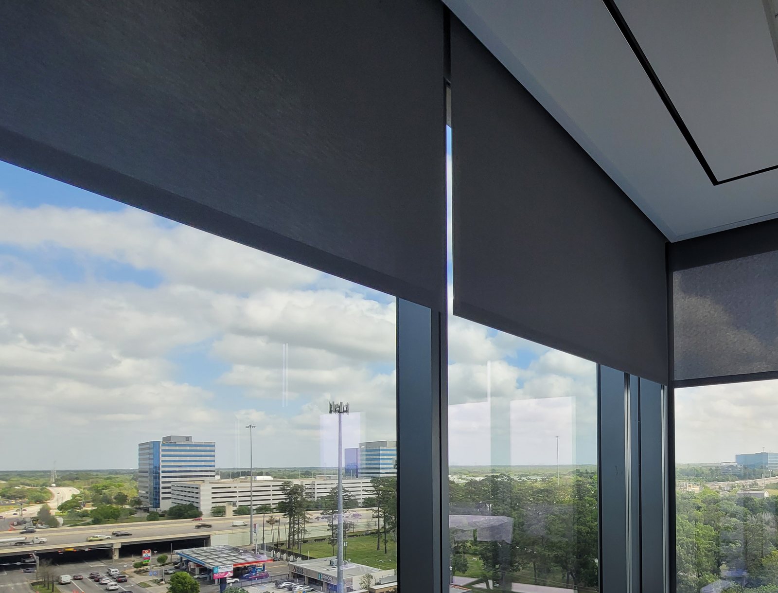 Roller shades on floor-to-ceiling windows in a high-rise office
