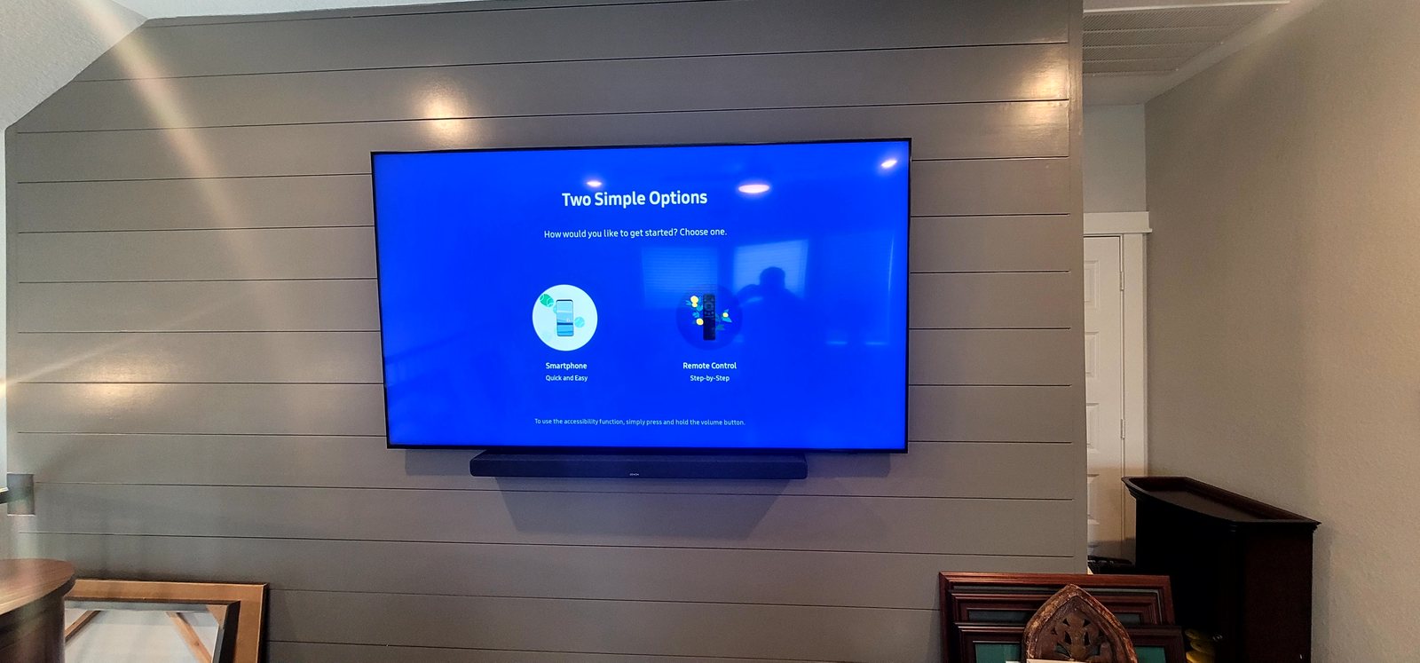 Wall-mounted television and soundbar on a shiplap wall