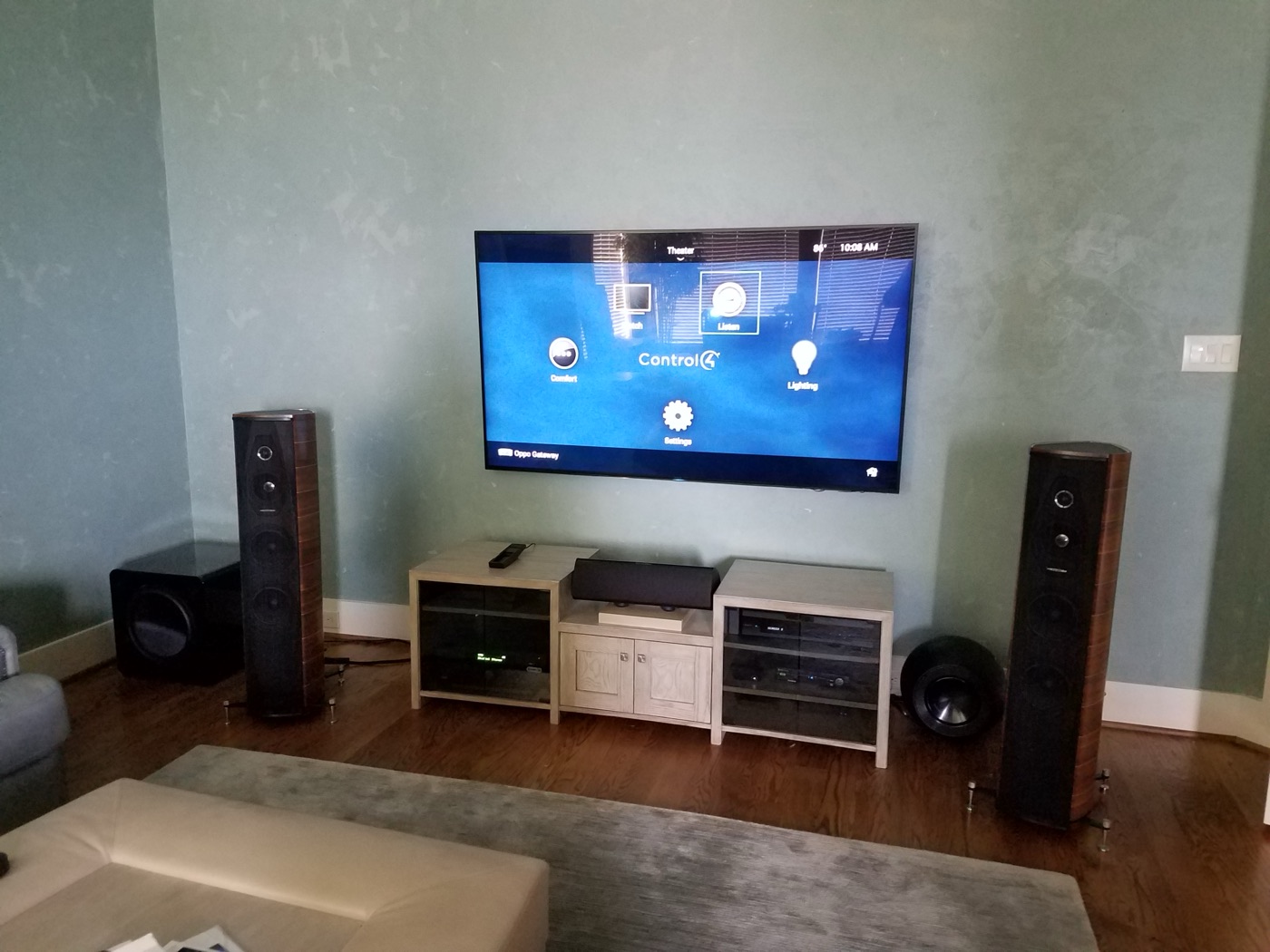 Wider view of the same Woodlands room: Control4 interface, Sonus Faber towers, two subwoofers and equipment cabinets