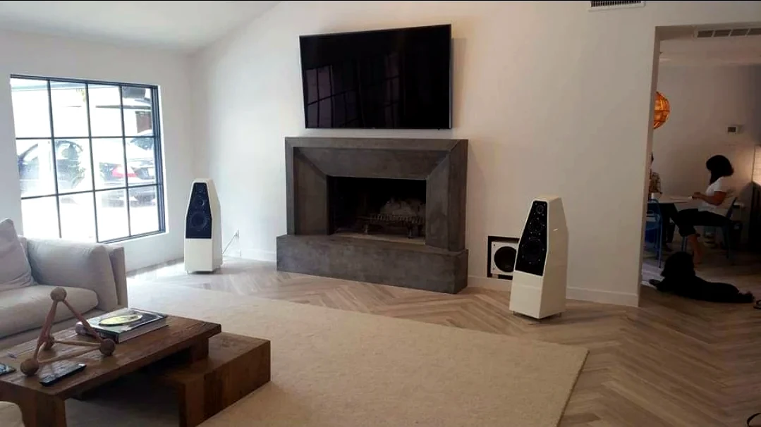 Modern living room with wall mounted TV fireplace and high end floorstanding speakers