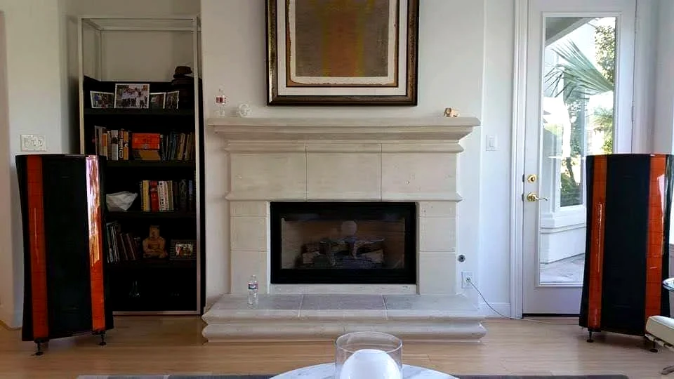 Residential two channel listening room with floorstanding speakers beside a fireplace in a Houston home